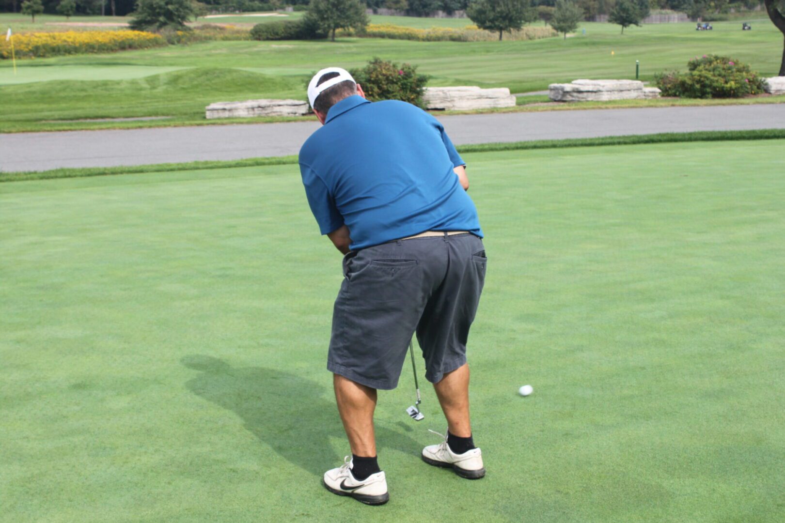 A man is putting a golf ball on a green.