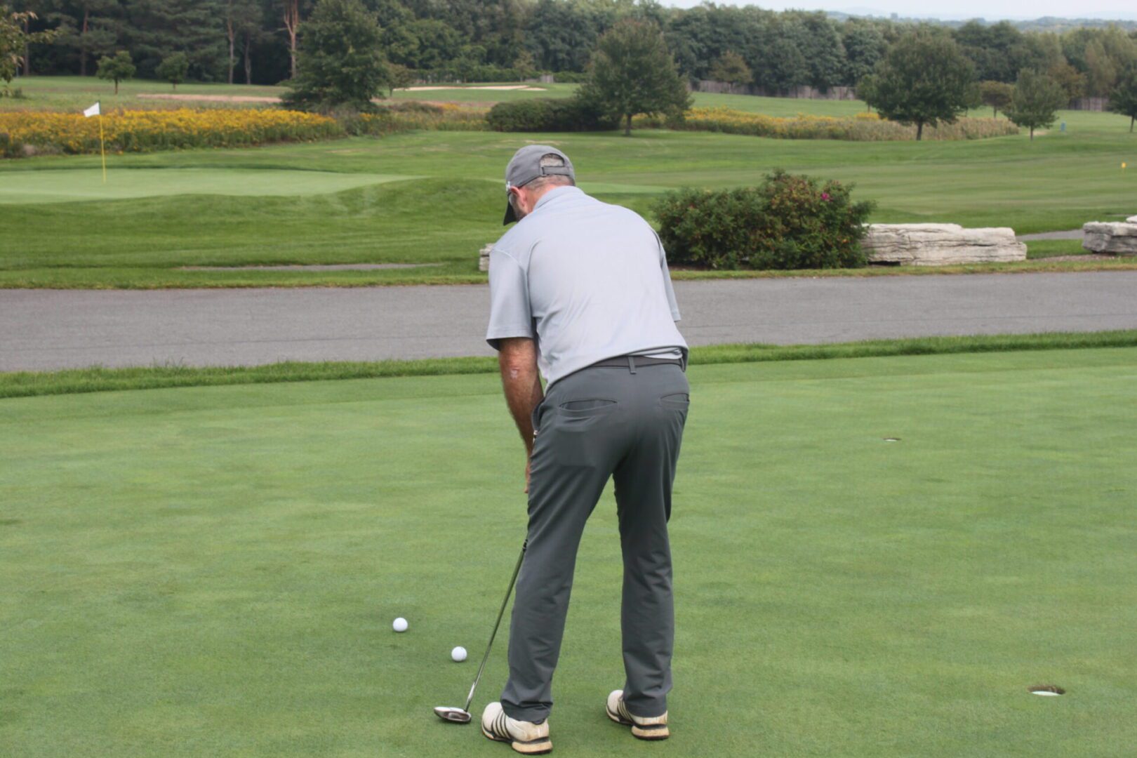 A man is putting on a golf course.