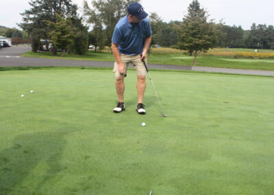 A man is putting a golf ball on a green.