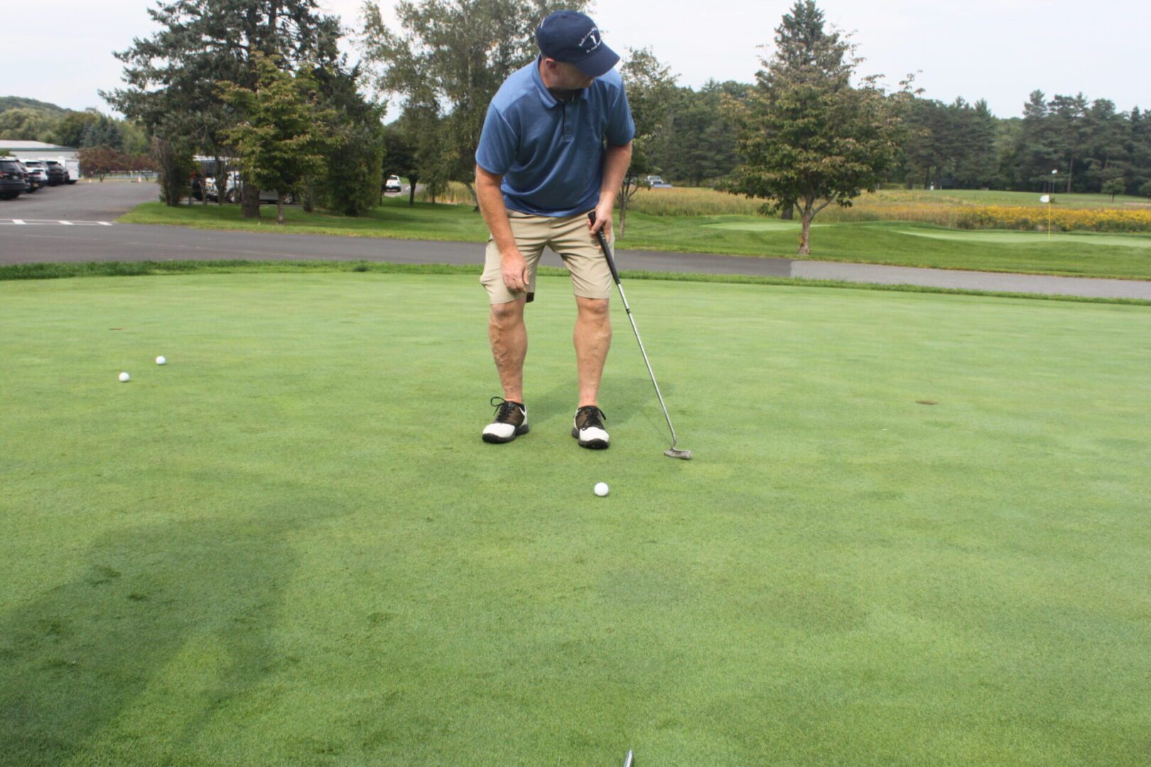 A man is putting a golf ball on a green.
