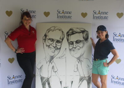 Two women standing next to a caricature of two men.