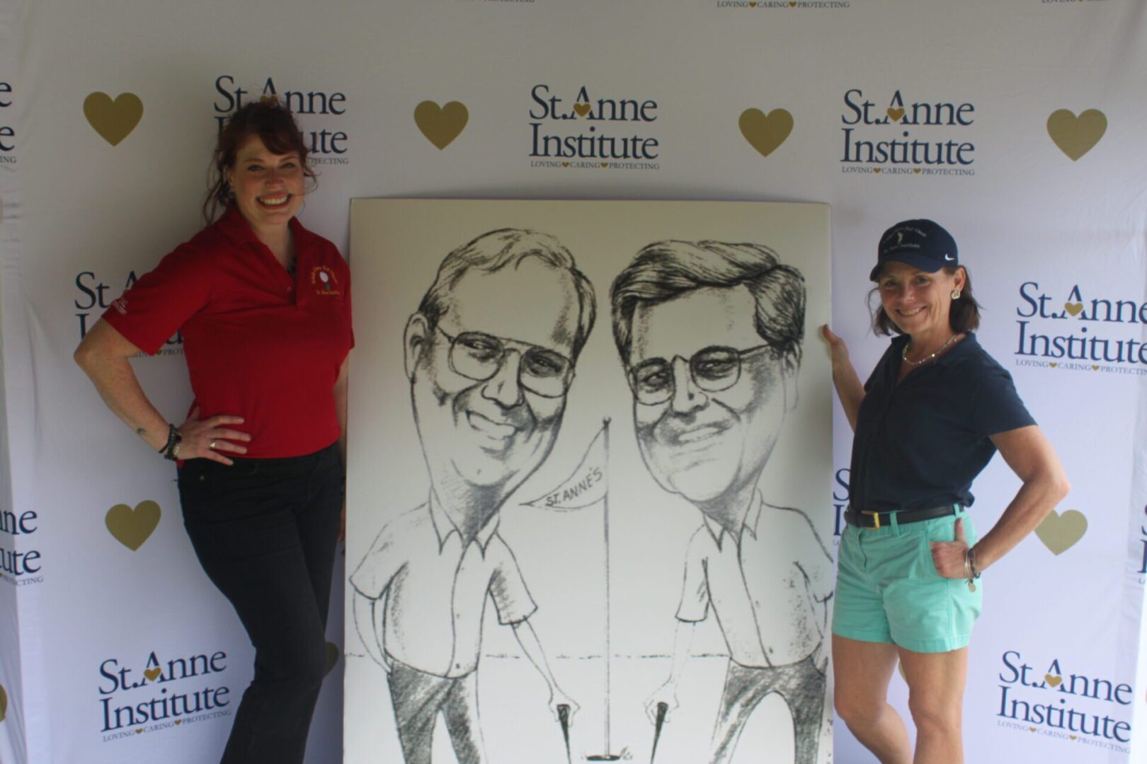 Two women standing next to a caricature of two men.