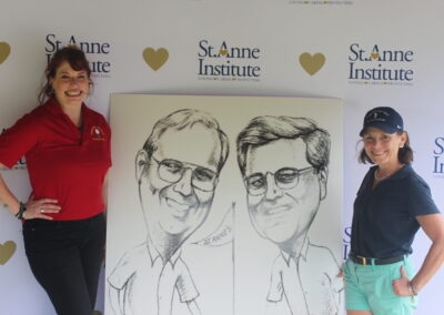 Two women standing next to a caricature of two men.