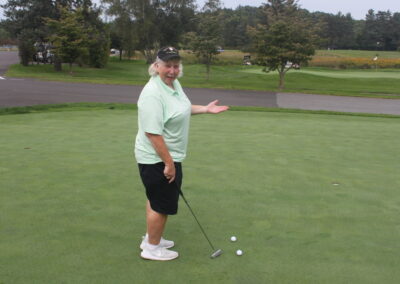 A man standing on a golf course with a golf ball.