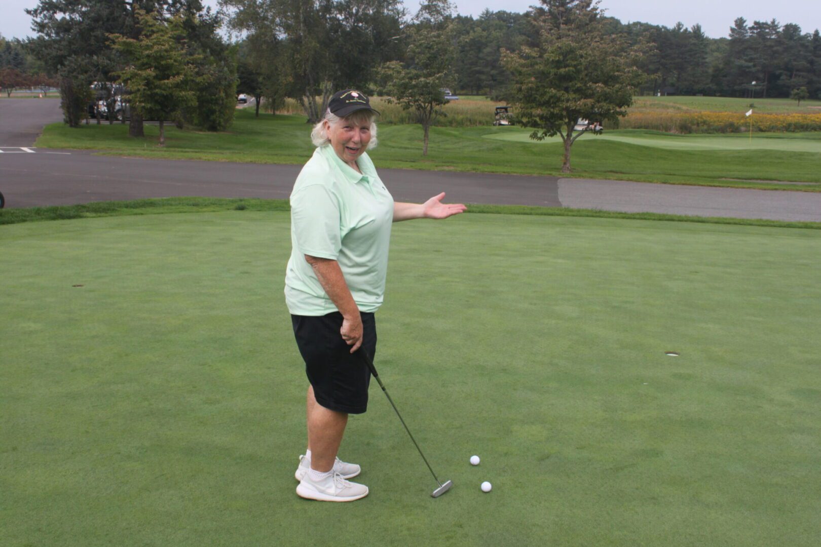 A man standing on a golf course with a golf ball.