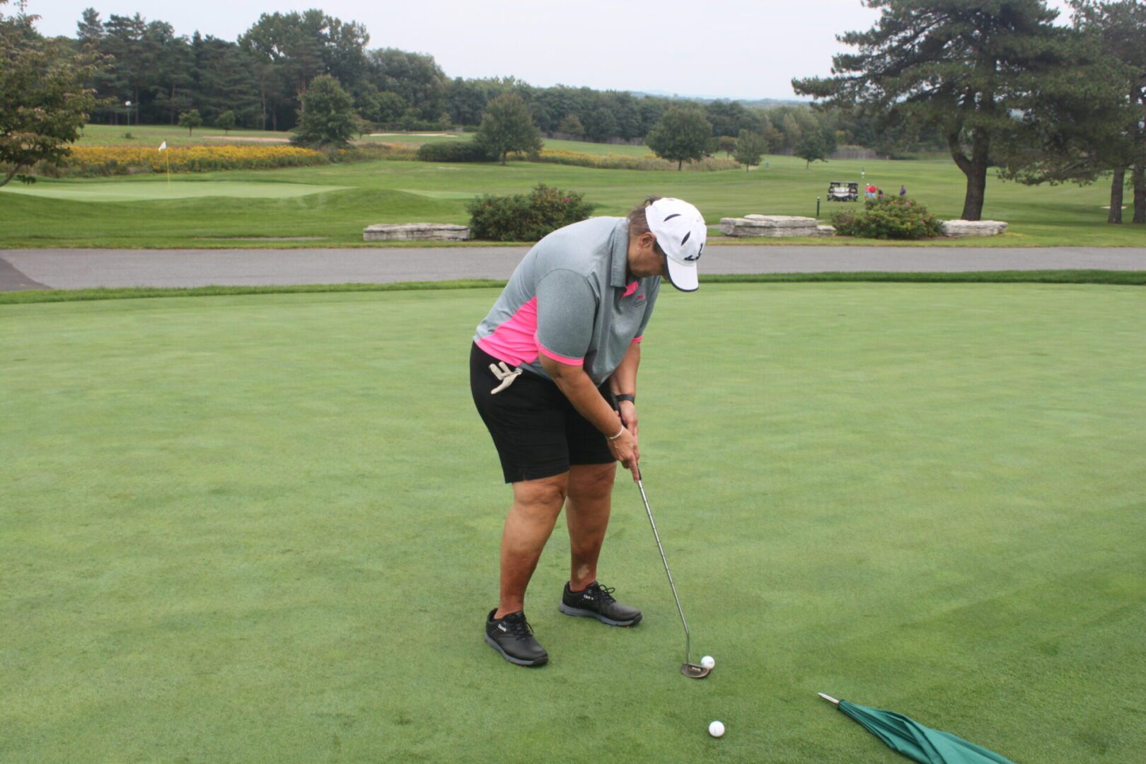 A man is putting a golf ball on a green.