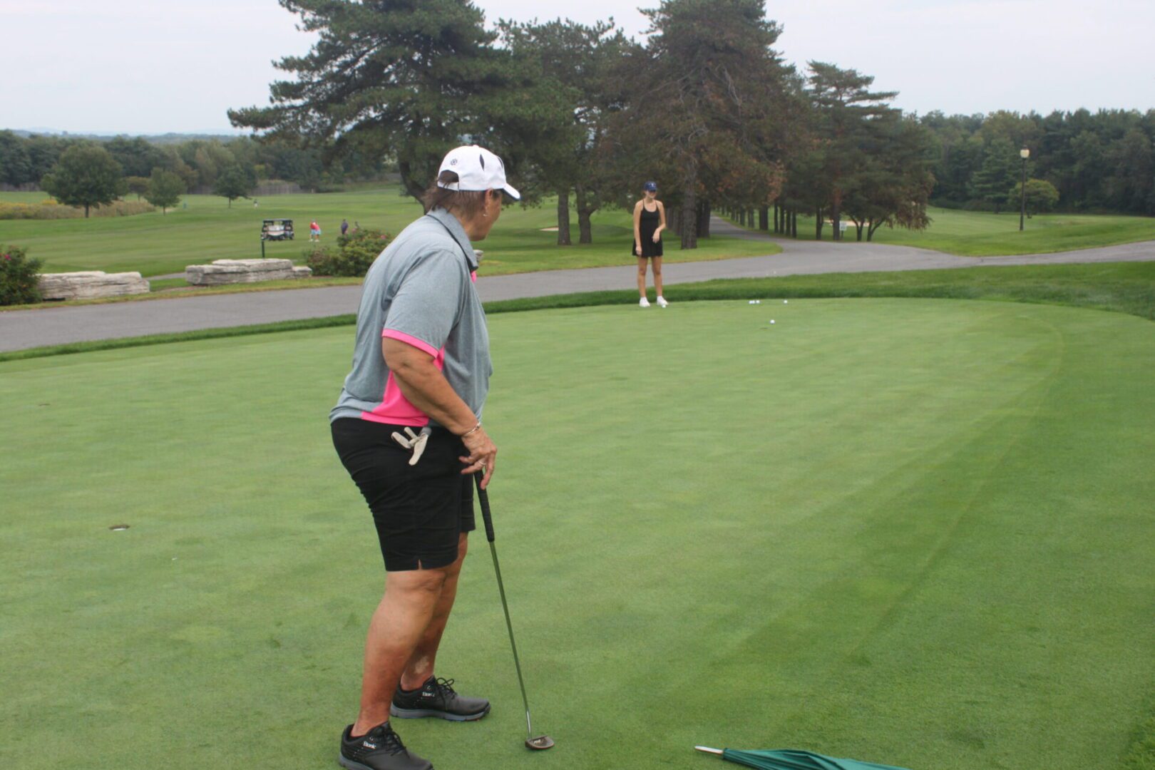A man is putting a golf ball on a green.