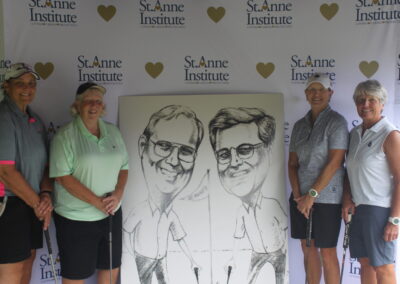 A group of people posing with a caricature.