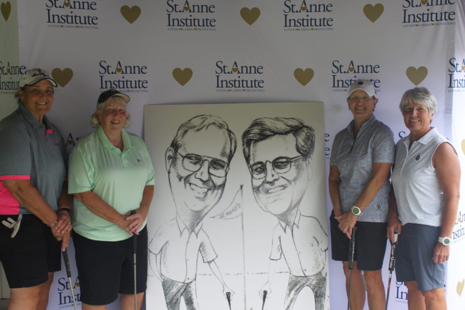 A group of people posing with a caricature.