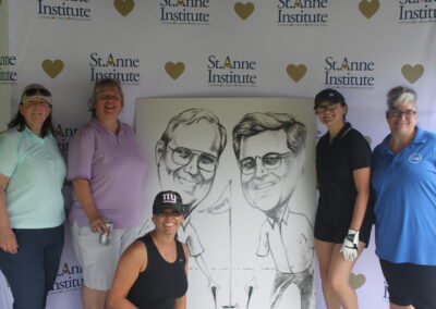 A group of women posing for a photo with a caricature.