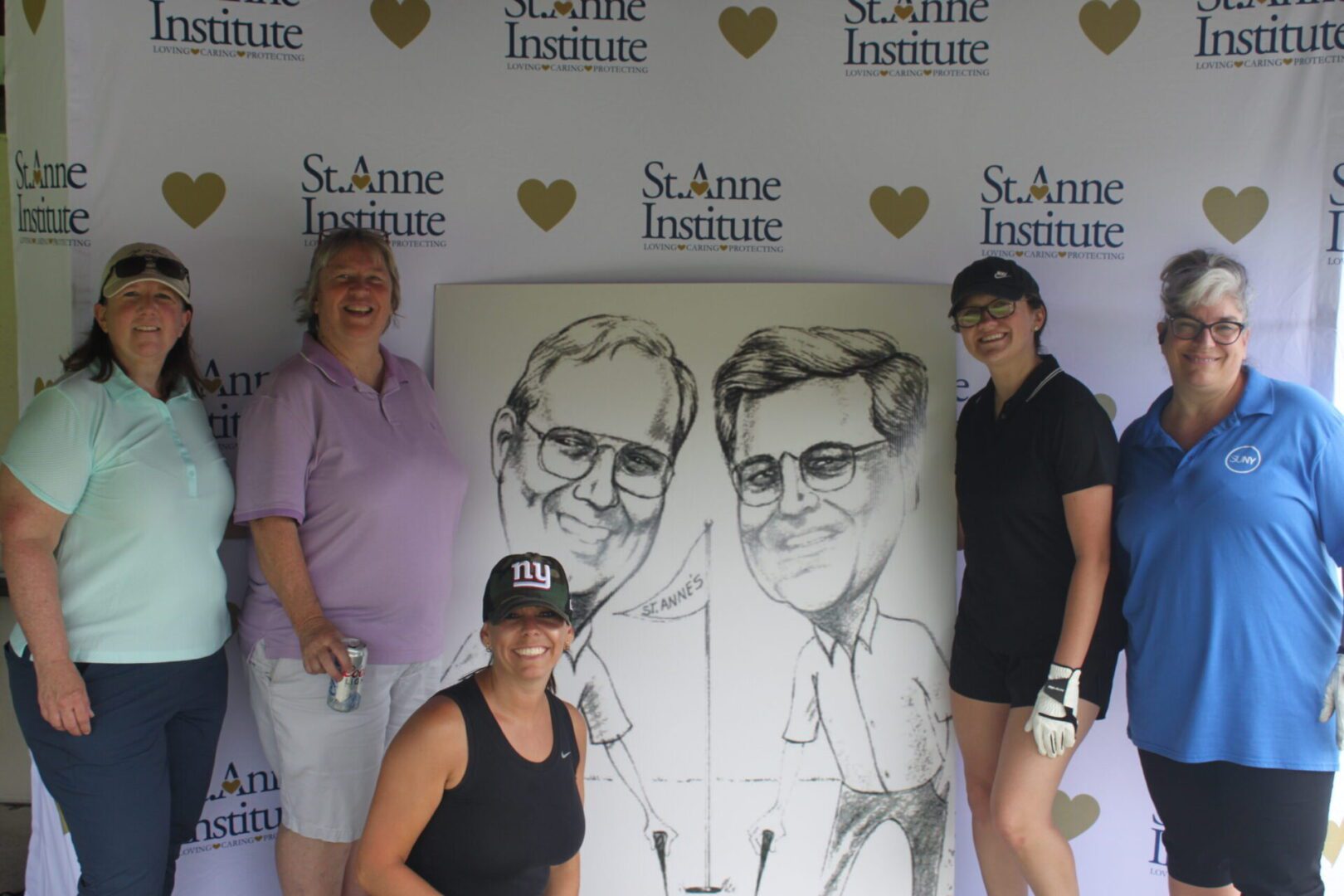 A group of women posing for a photo with a caricature.