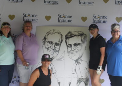 A group of people posing for a photo with a caricature.