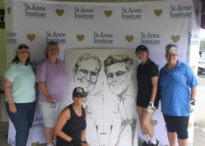 A group of women posing for a photo with a caricature.