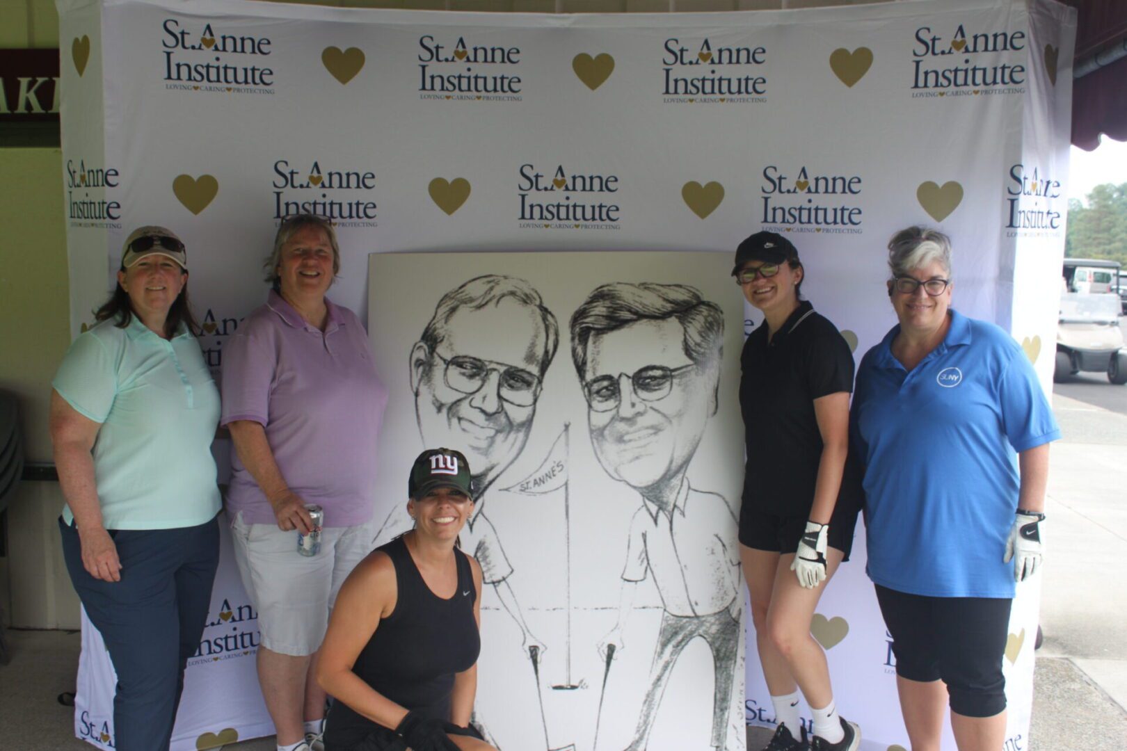 A group of women posing for a photo with a caricature.