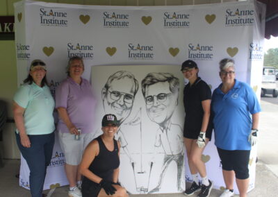 A group of women posing for a photo with a caricature.