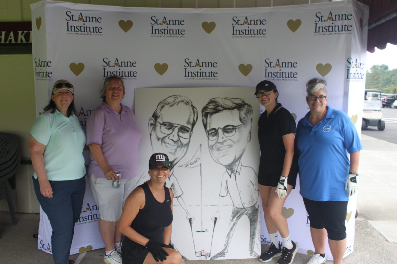 A group of women posing for a photo with a caricature.