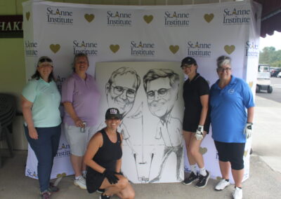 A group of women posing for a photo with a caricature.