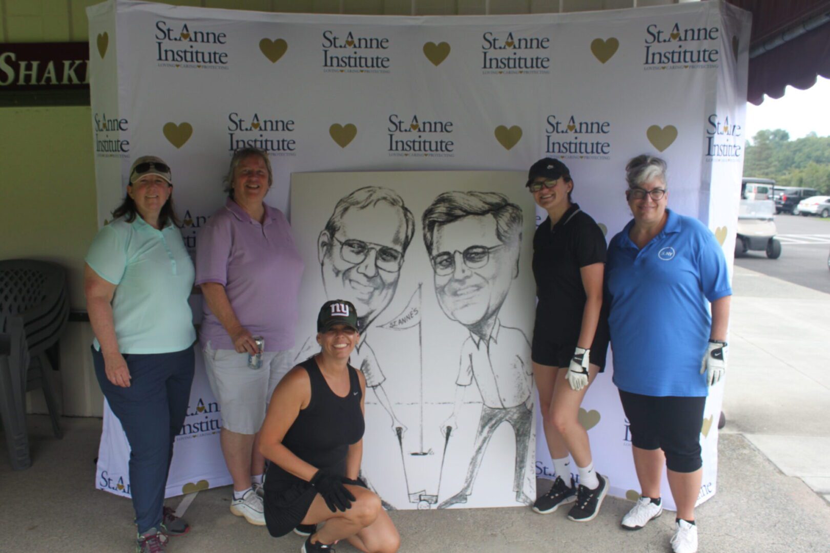 A group of women posing for a photo with a caricature.