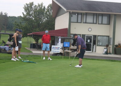 A group of people standing on a golf course.