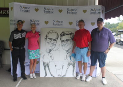 A group of people posing in front of a caricature.