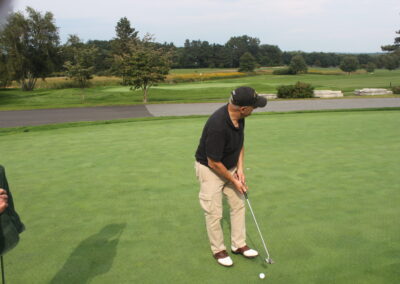 A man is putting a putt on a golf course.