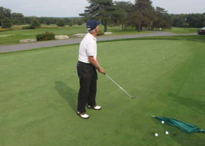 A man is putting a golf ball on a green.