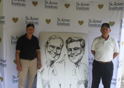 Two men standing next to a caricature.