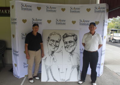 Two men standing next to a caricature.