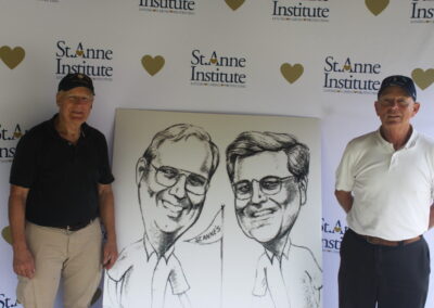 Two men standing next to a caricature.