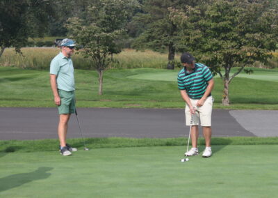 A group of people standing on a golf course.