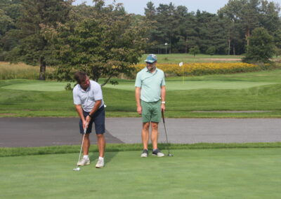 Two men playing golf on a golf course.