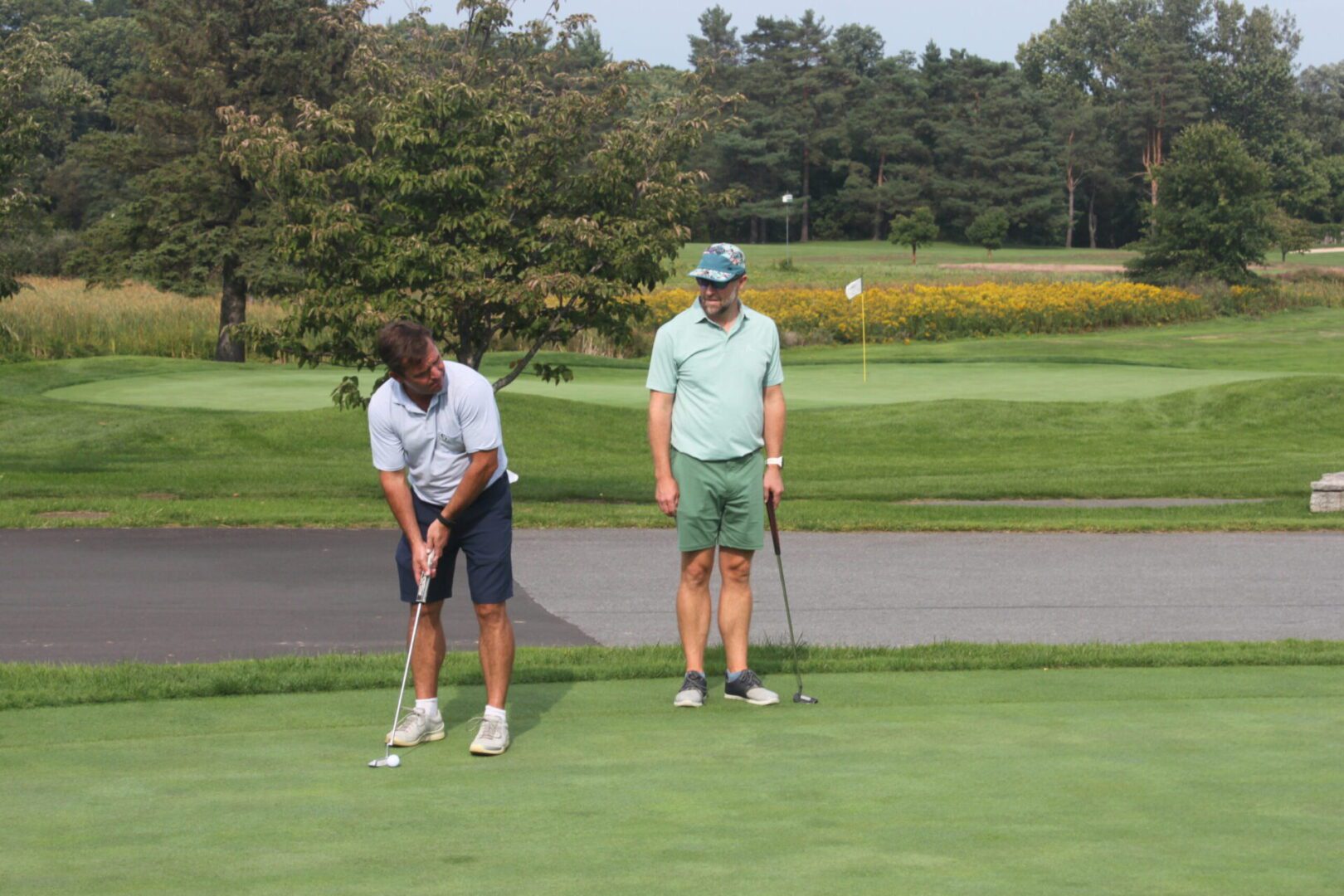Two men playing golf on a golf course.