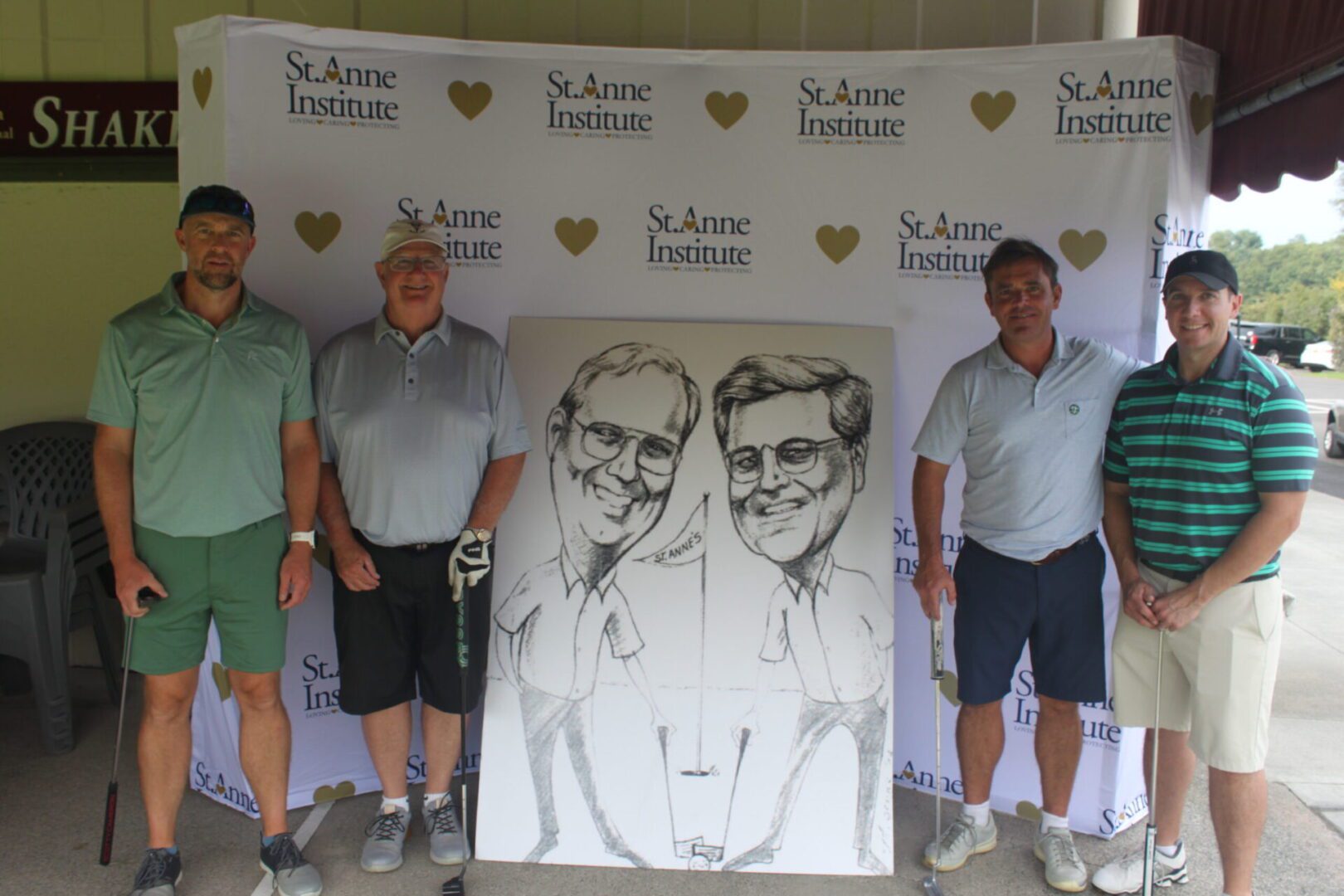 A group of men posing for a photo with a caricature.