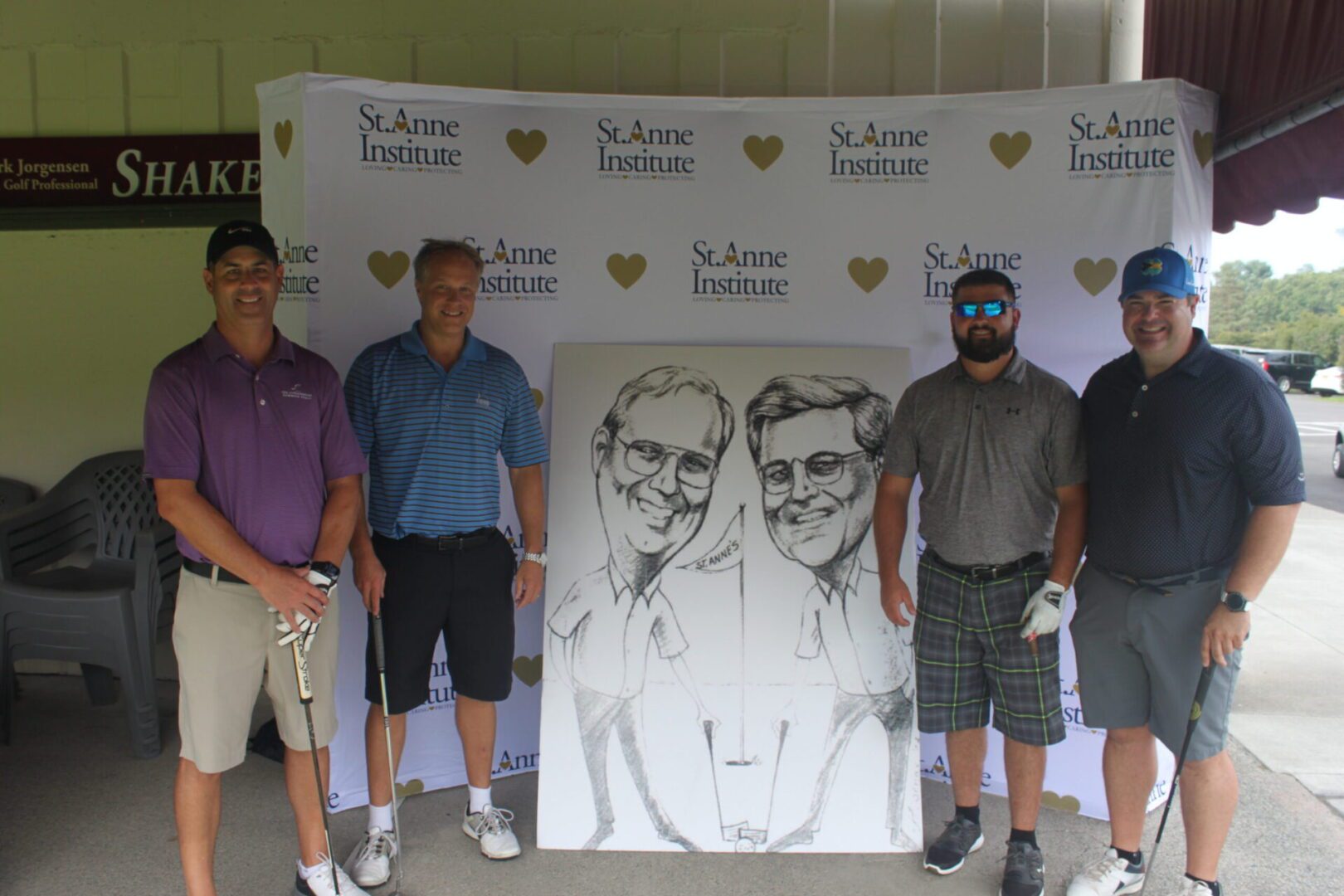 A group of men posing for a photo with a caricature.