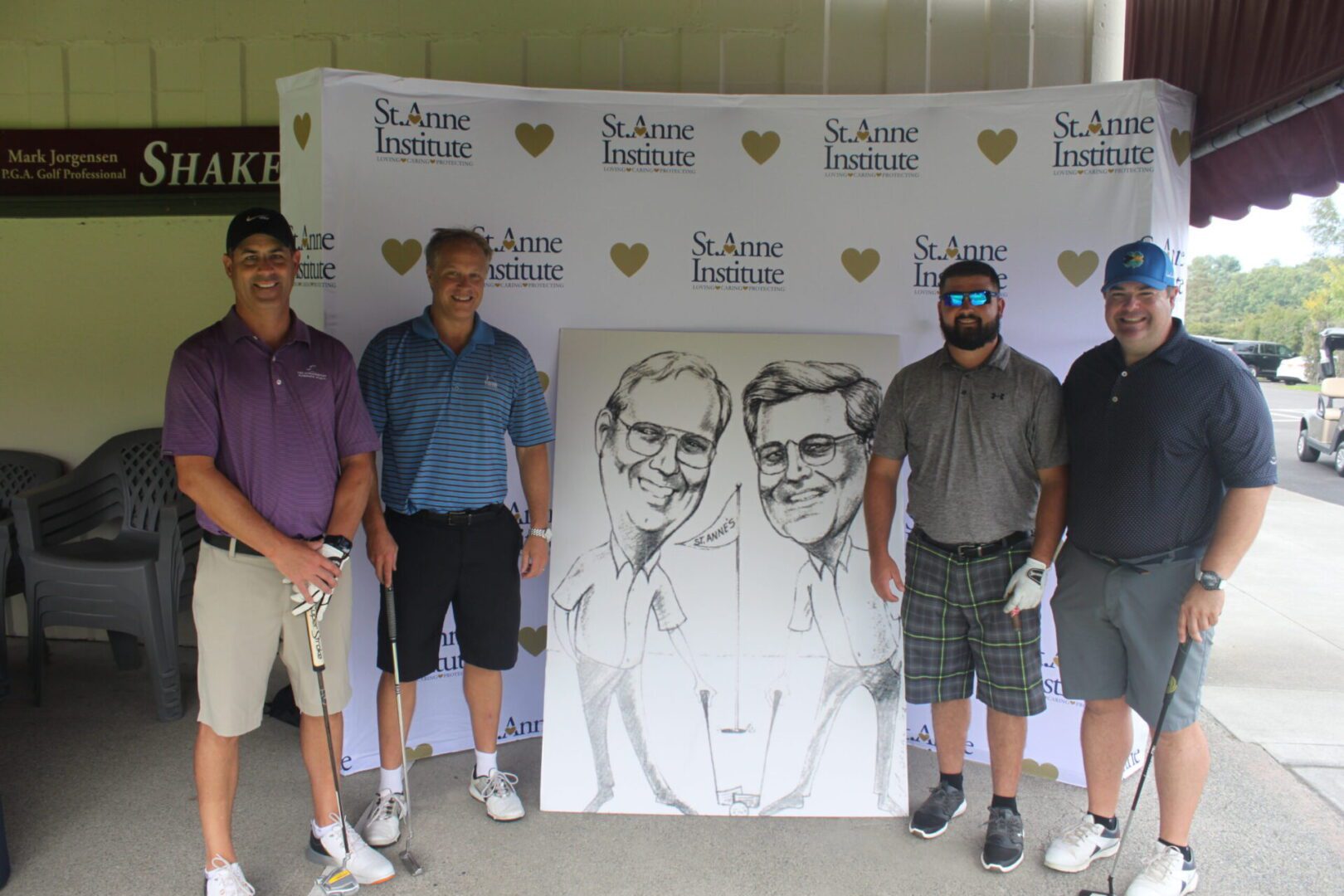 A group of men posing for a photo with a caricature.