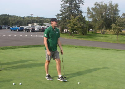 Two men standing on a green putting green.