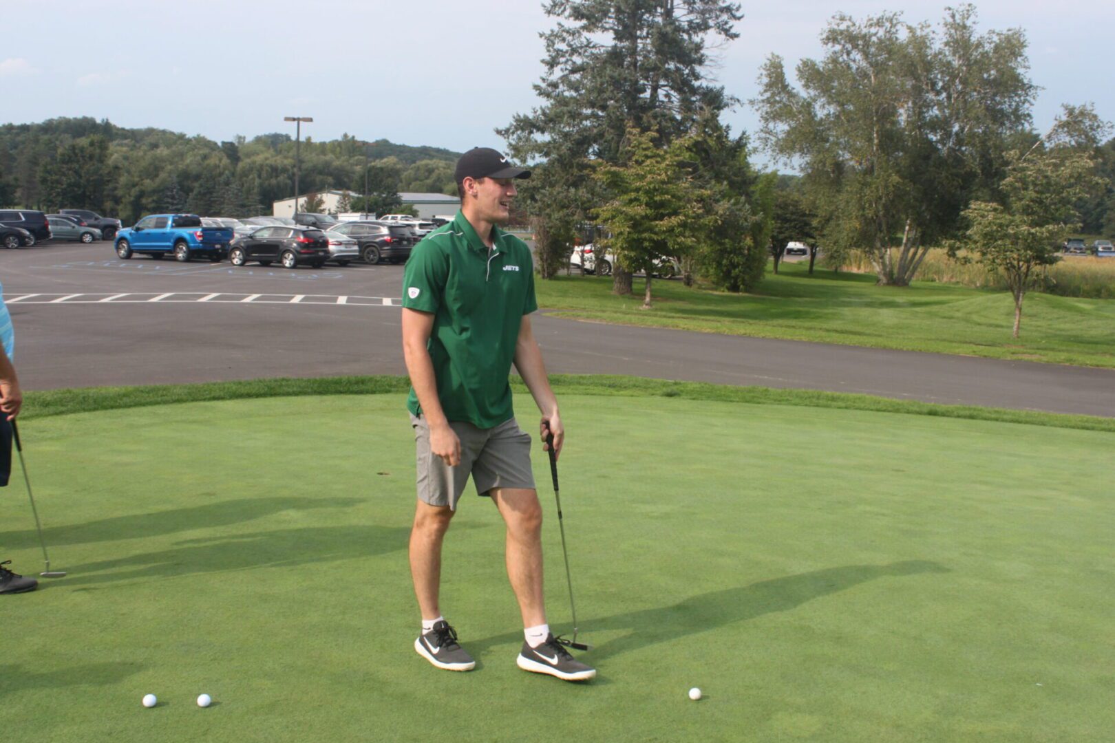 Two men standing on a green putting green.