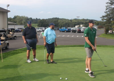 A group of men standing on a green golf course.