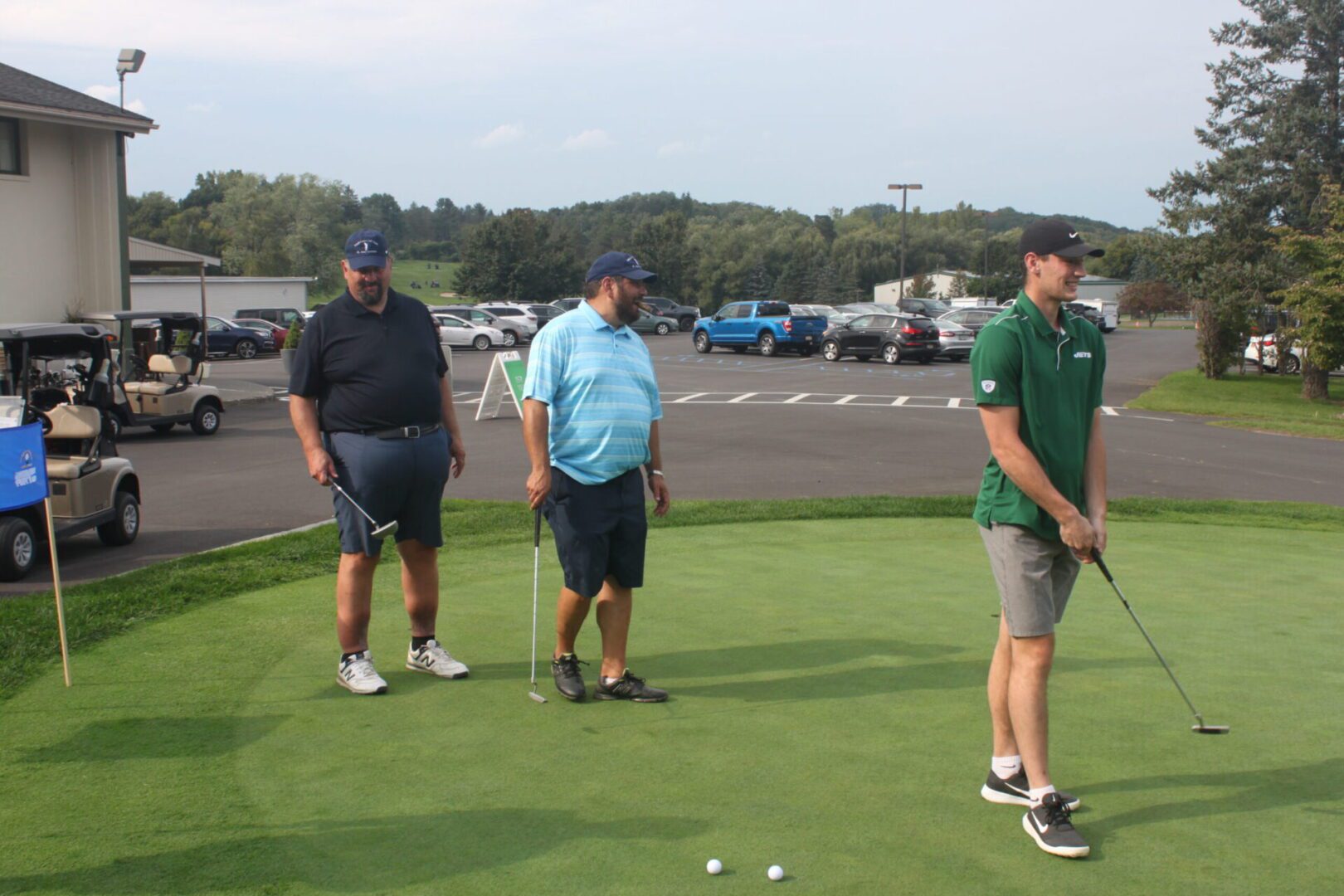 A group of men standing on a green golf course.