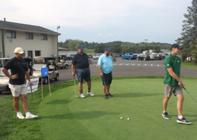 A group of men playing golf in a parking lot.