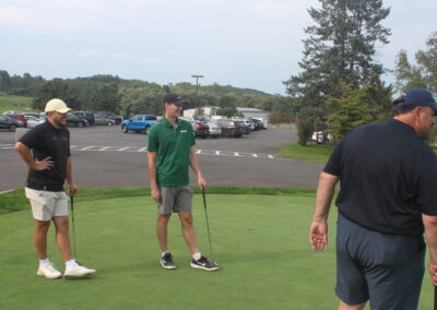 A group of people standing on a golf course.