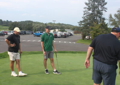 A group of people standing on a golf course.