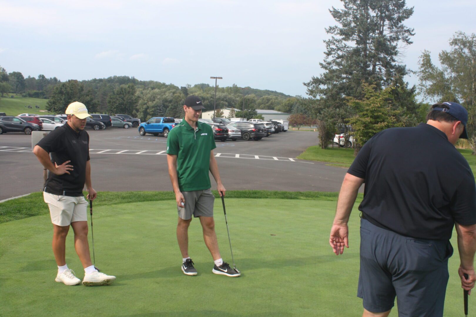 A group of people standing on a golf course.