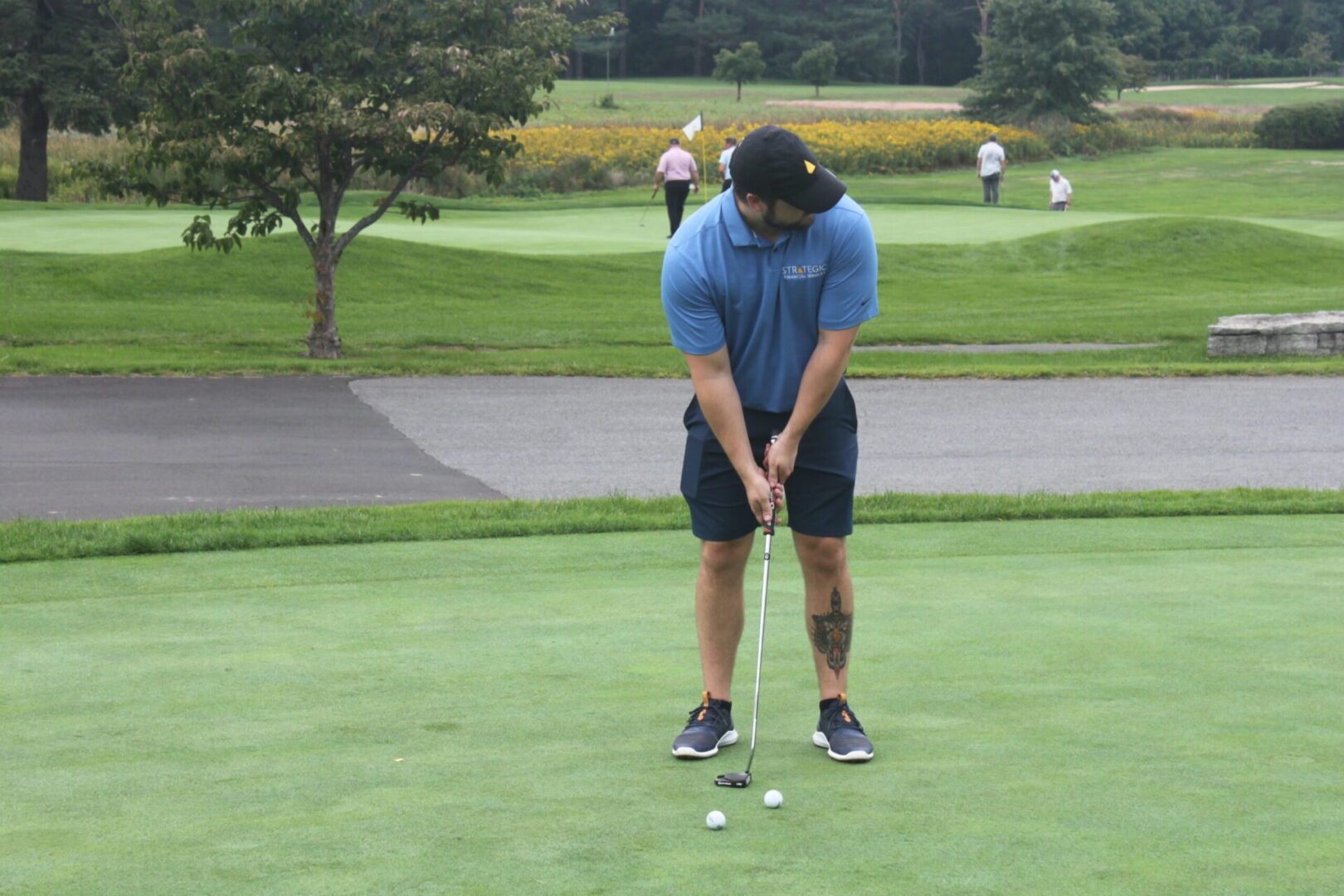 A man is putting a ball on a golf course.