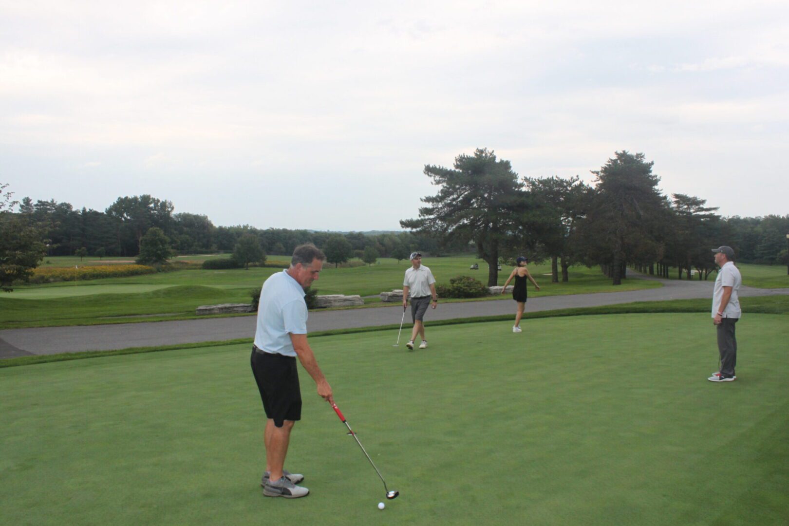 A group of people on a golf course.