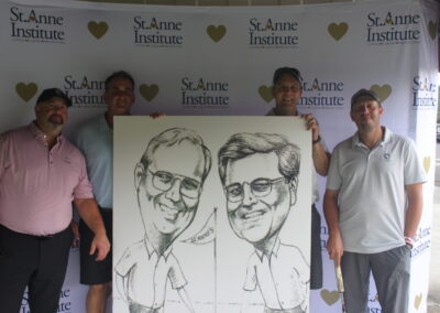 A group of men posing with a caricature.