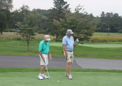 Two men standing on a golf course.