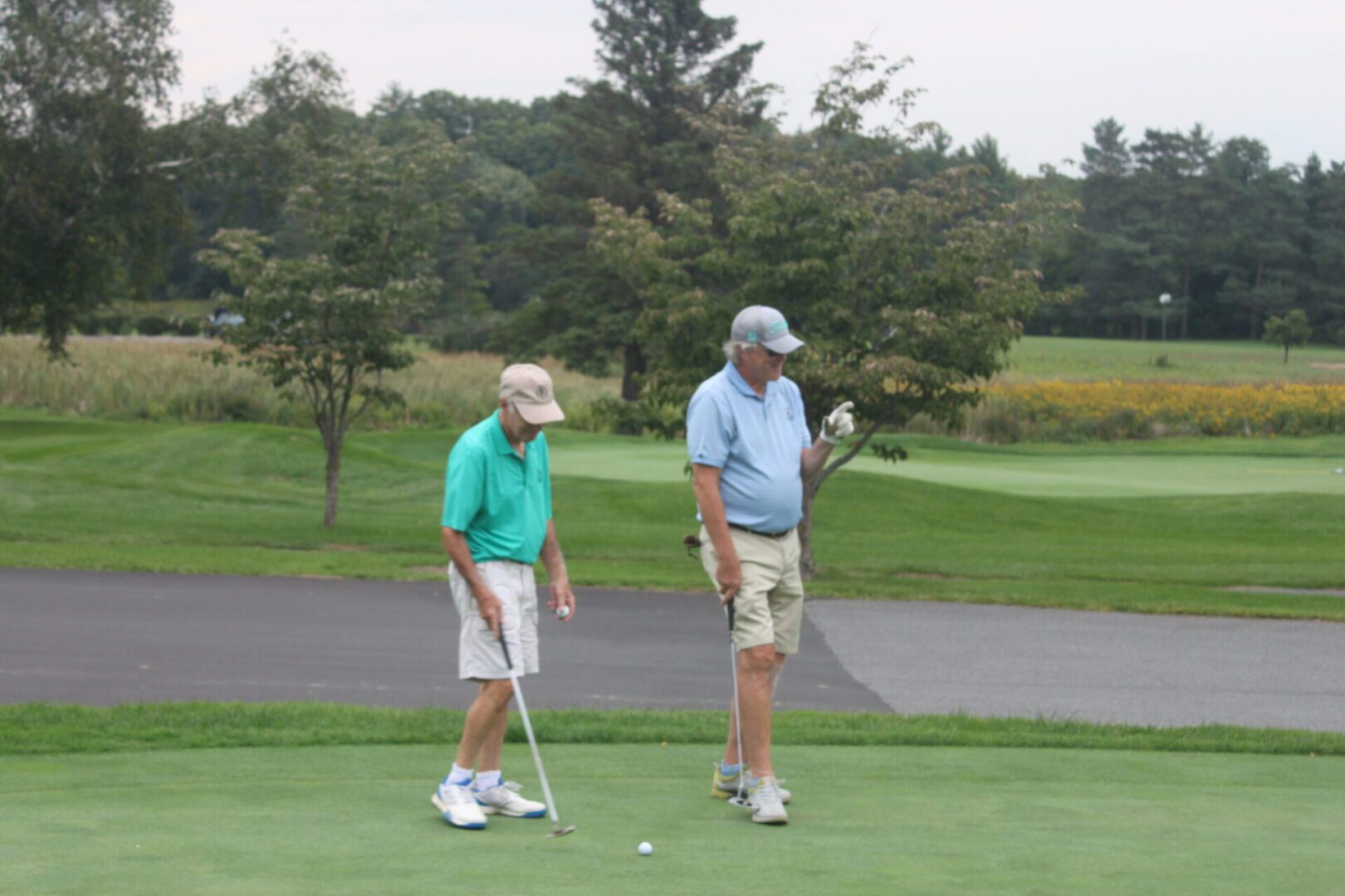 Two men standing on a golf course.