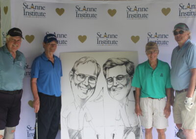 Two men standing next to a large drawing of men.