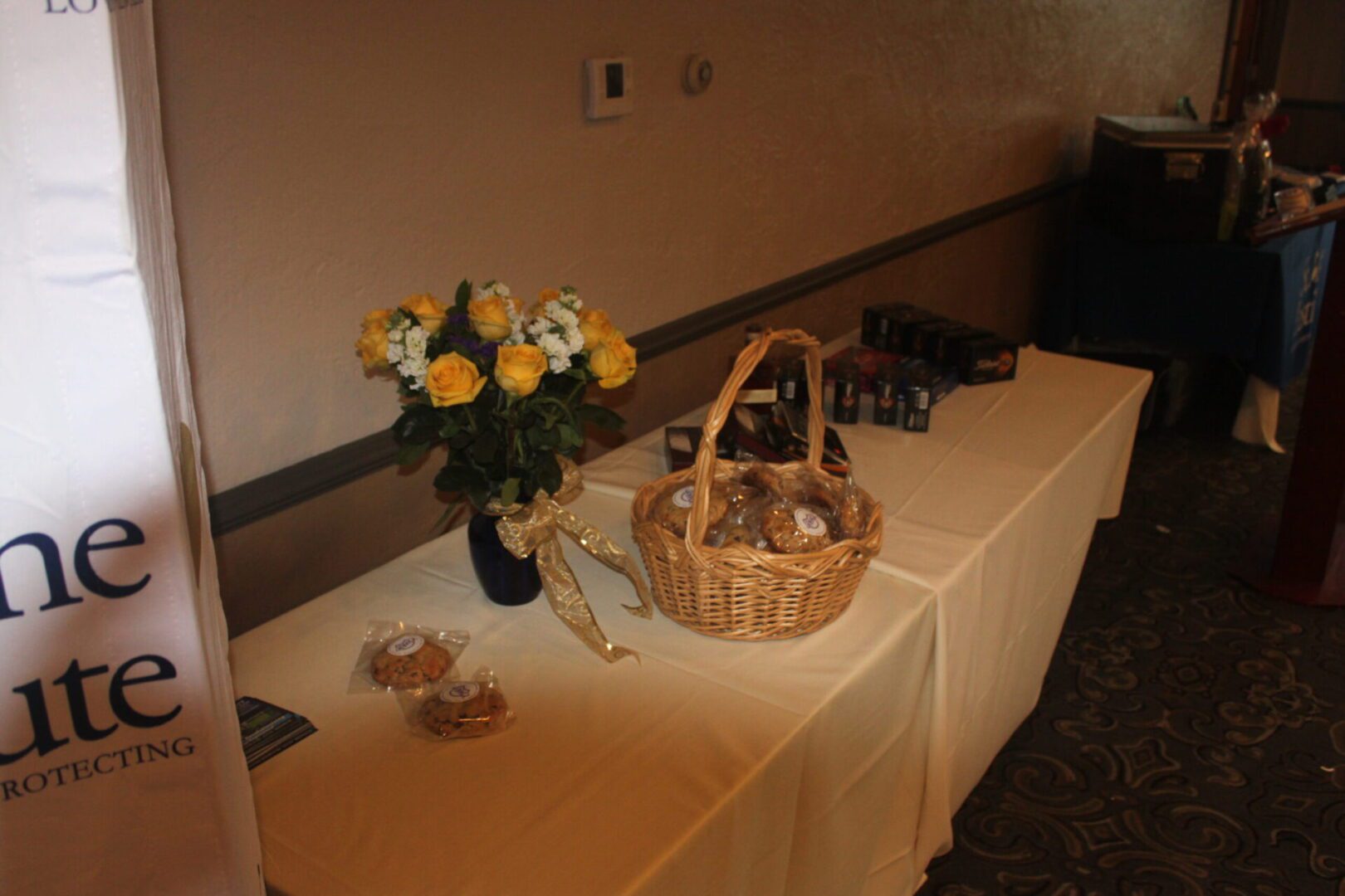 A table with a basket of cookies and flowers.